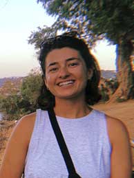 Photo of Ms. Donnellan, smiling, in front of arid landscape and a body of water