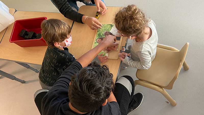 High school student works with preschool children