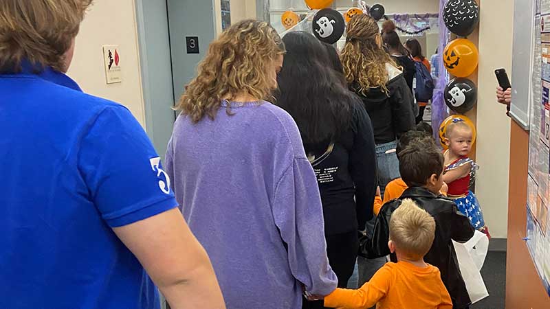 Students, staff, and preschoolers trick or treat at central administrative offices on a field trip