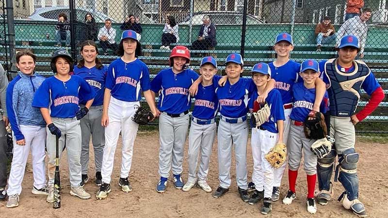 Photo of middle grades boys baseball team standing at home base