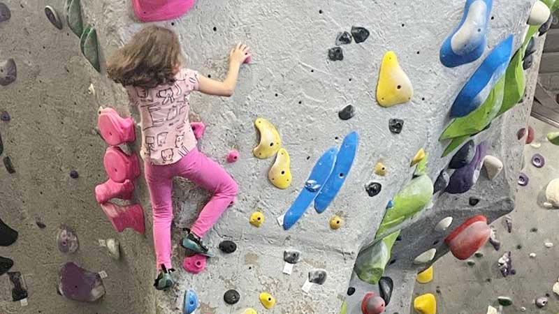 Girl in afterschool on a climbing wall. 