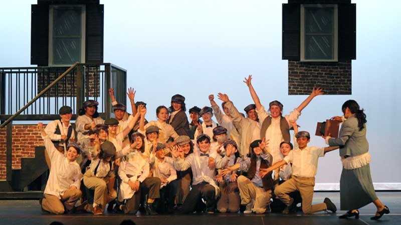 middle grades acting troupe on stage for Newsies production