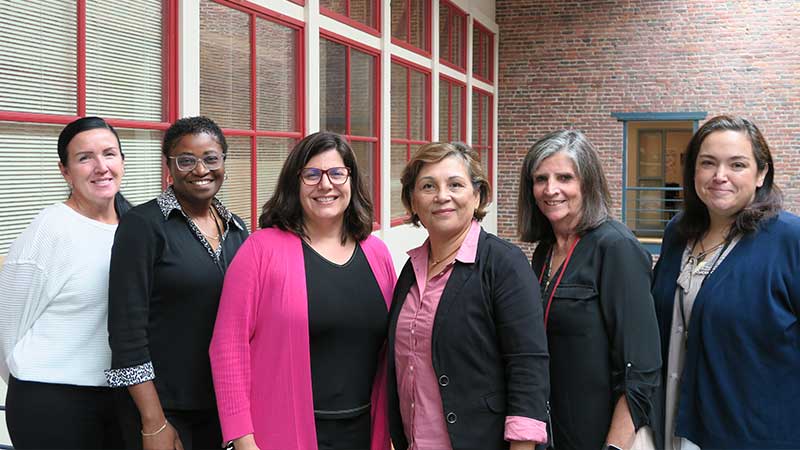 Enrollment Office team members in front of a staircase