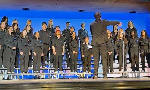 Student chorus singing on stage