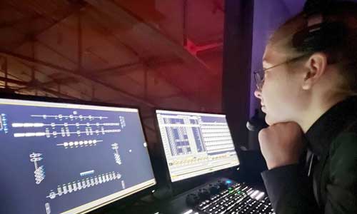 Student looks at screens for theater production