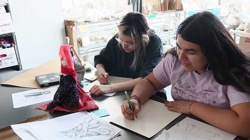 Two students working on a fashion project in the art studio