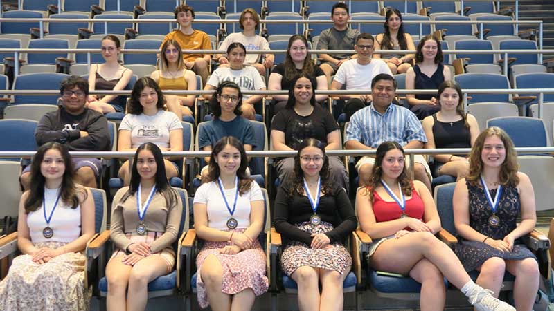 Students in the lecture hall posing for a photo with others who earned the Seal of Biliteracy Award